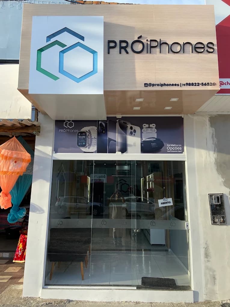 Fachada da Pró iPhones em Santo Estêvão: placa com o logo hexagonal, vitrine de vidro e a plaquinha de aberto